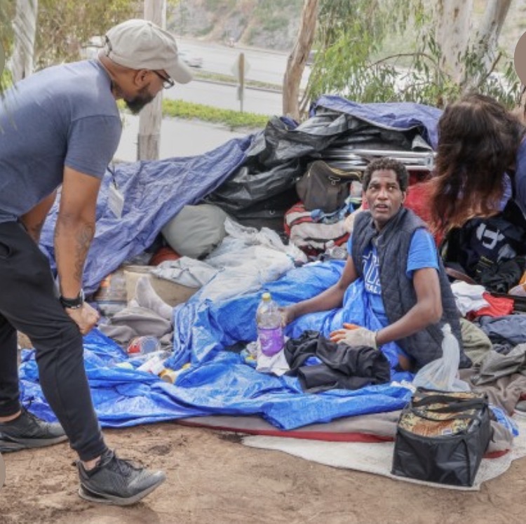 A TPWG outreach worker engages a young man at an encampment