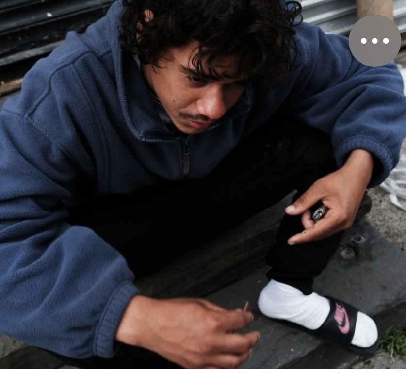 A young man sits alone, contemplative — a quiet moment of the crisis